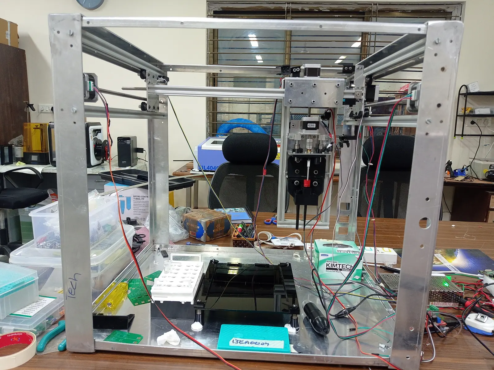 The 5-axis deposition machine on the bench: extruded aluminium frame, stepper motors, lead screws and the deposition head