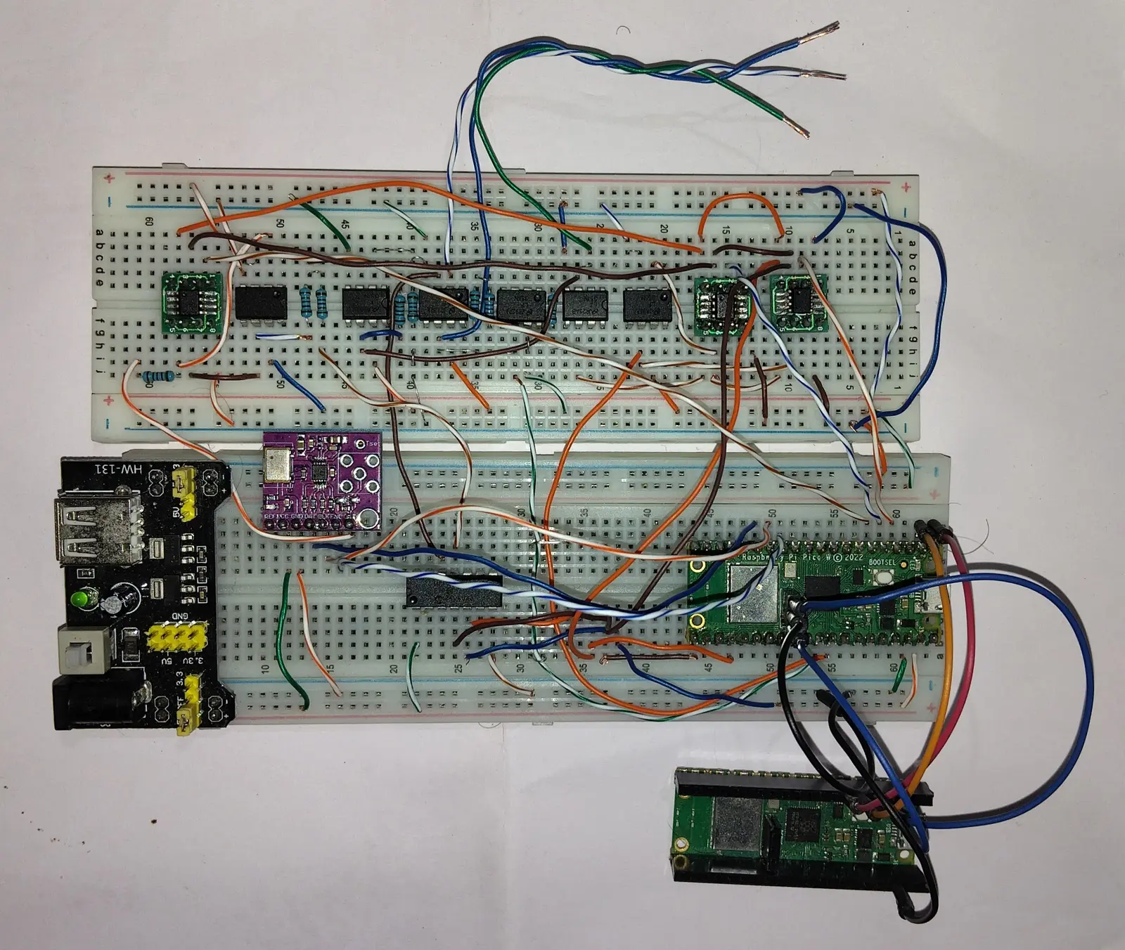 Potentiostat bring-up: a Raspberry Pi Pico W wired across two breadboards to a row of op-amps forming the analog front end