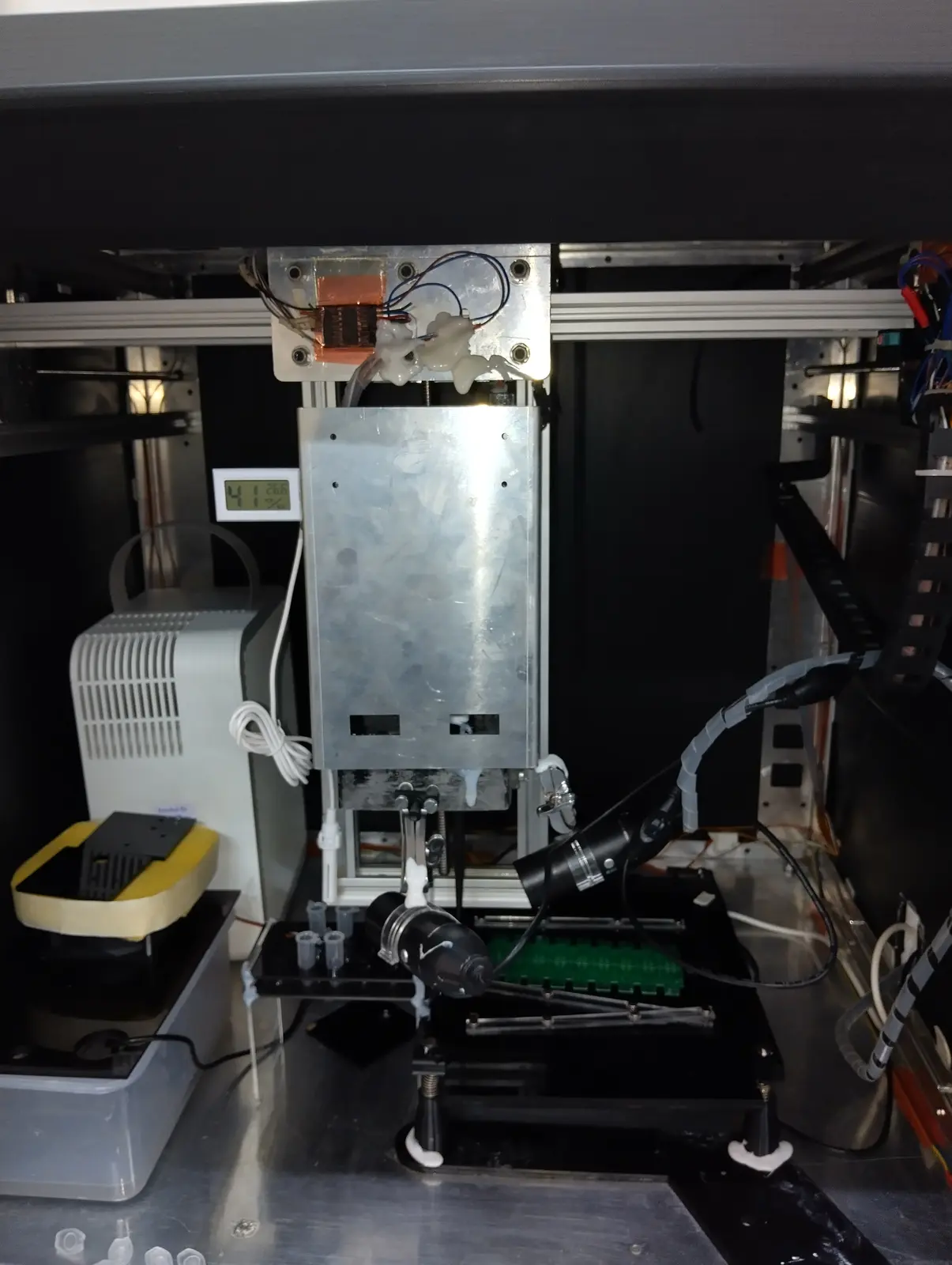 The same machine a revision later: enclosed, with a microscope on the head and a hygrometer inside the cabinet.