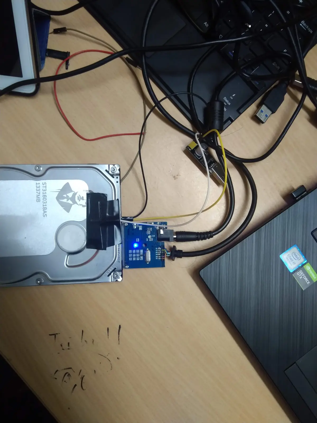A bricked Seagate ST3160318AS wired to a USB-TTL adapter — talking to the drive’s diagnostic serial port to bring it back. Labelled 1337MB, naturally.